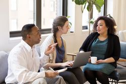 Three employees discussing a strategy in a business meeting