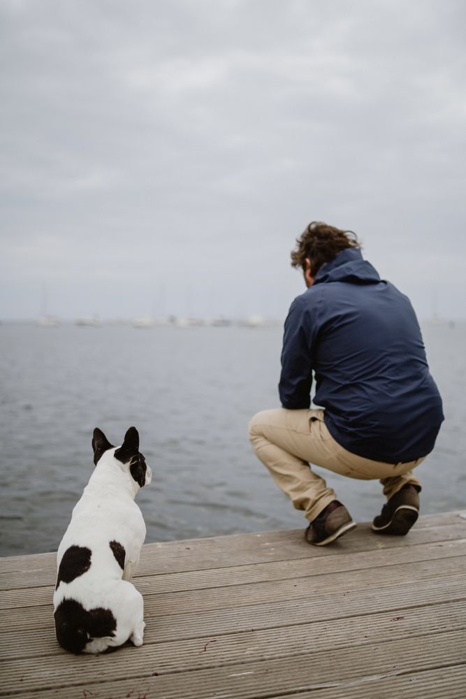 Man and dog sitting on pier