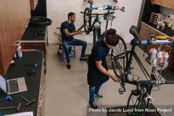 Workers repairing bicycles in a cycle shop bG2KY4