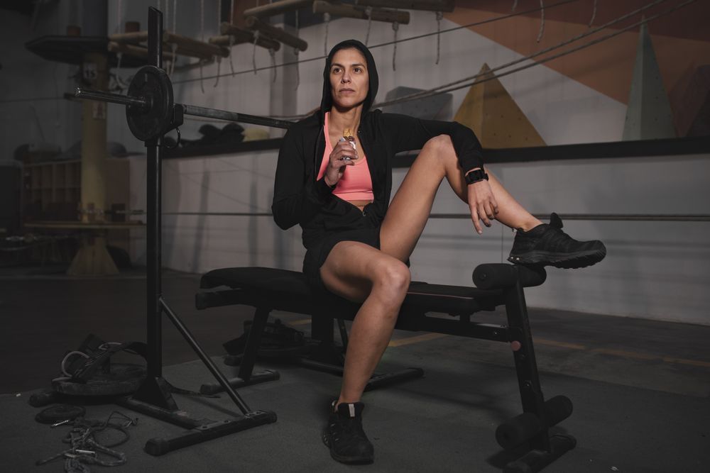 Smiling woman with energy bar in gym