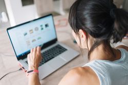 Back of woman working on laptop at home