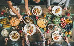 Group of people serving food over festive dishes and turkey