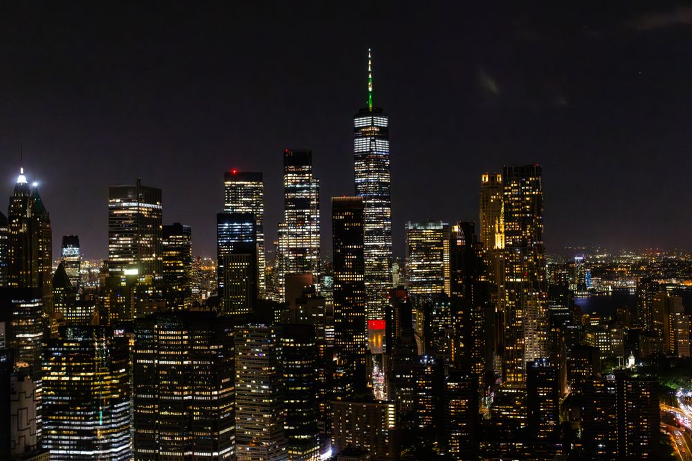 Aerial View of Manhattan Architecture at Night. Evening Shot of Financial Business District from a Helicopter. Scenery of Historic Office Towers, Illuminated Skyscrapers