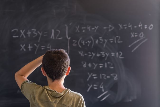 Teenager looking at equation on chalk board