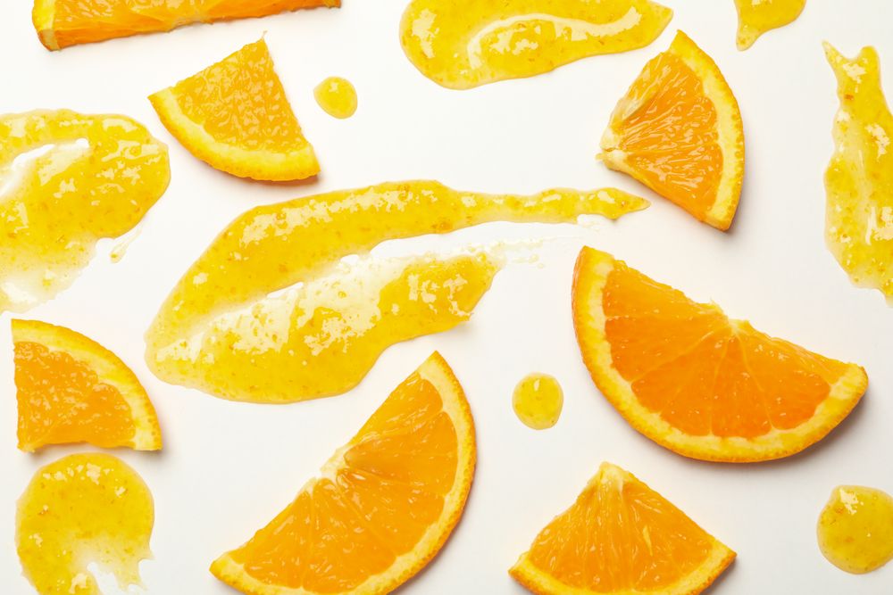 Composition with orange slices and jam on plain background