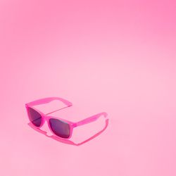 Pink sunglasses on pastel pink background
