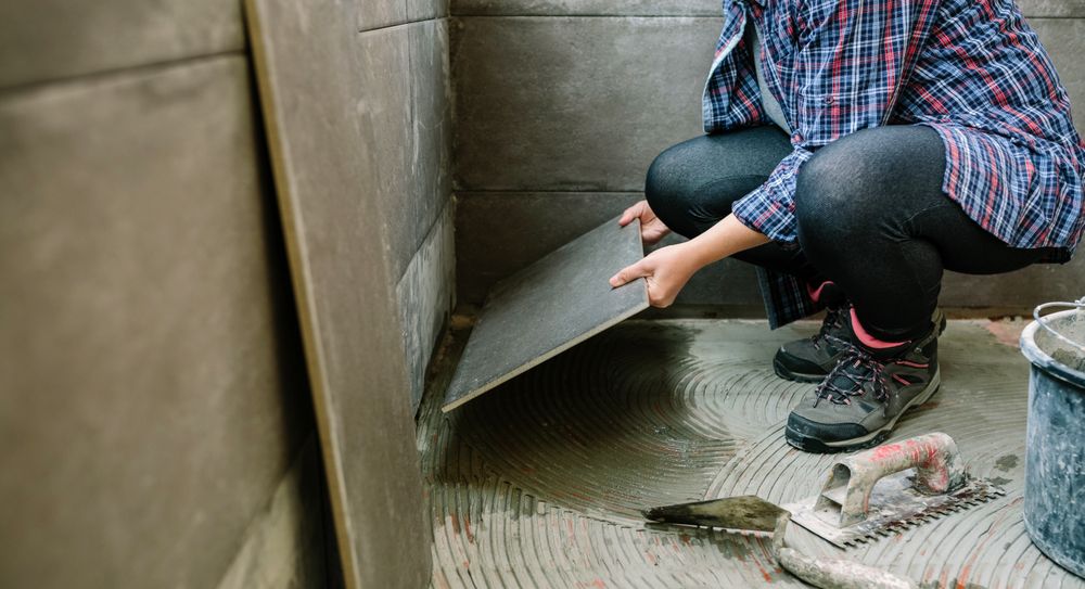 Female builder laying a new tile floor