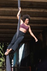 Healthy woman doing yoga with aerial silks in city
