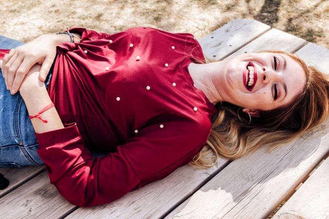 Smiling woman laying down on picnic table