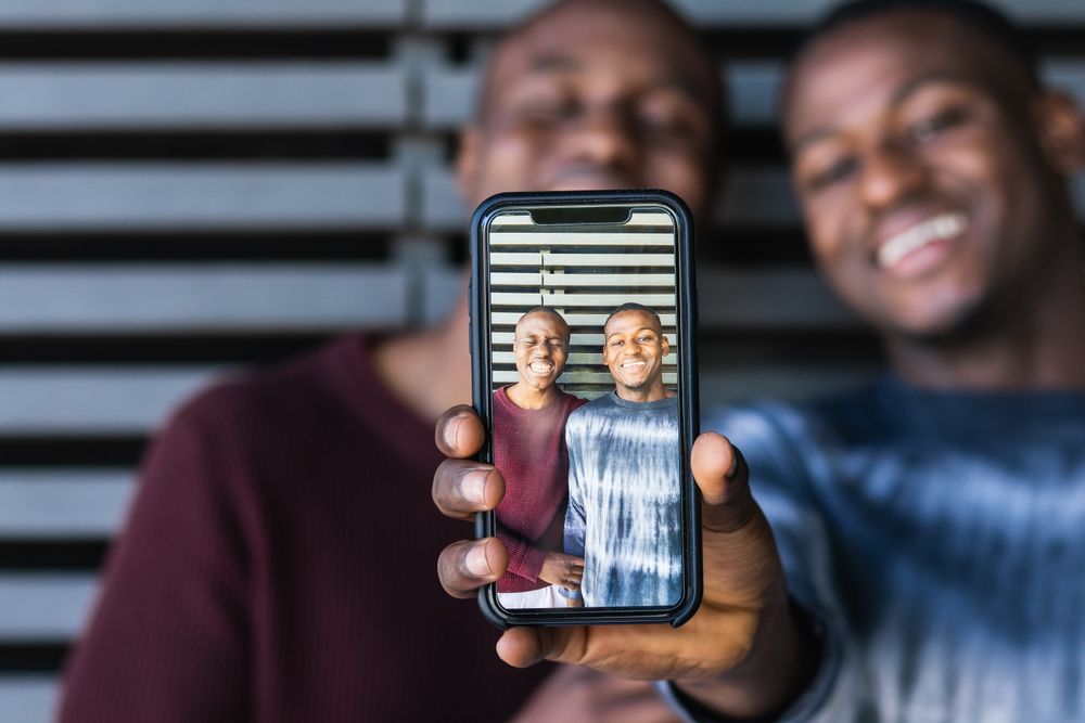 Showing photo on smartphone of Black friends