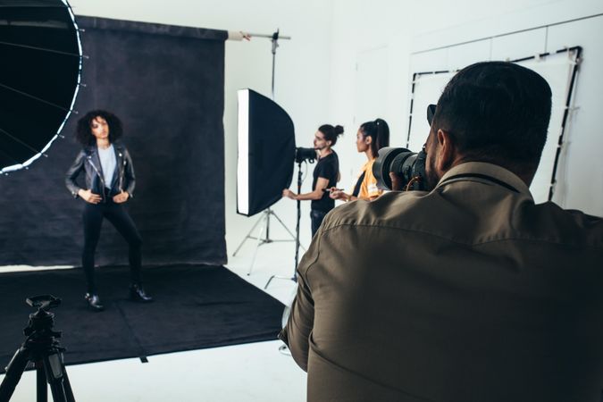 Photographer, crew and model posing in professional studio