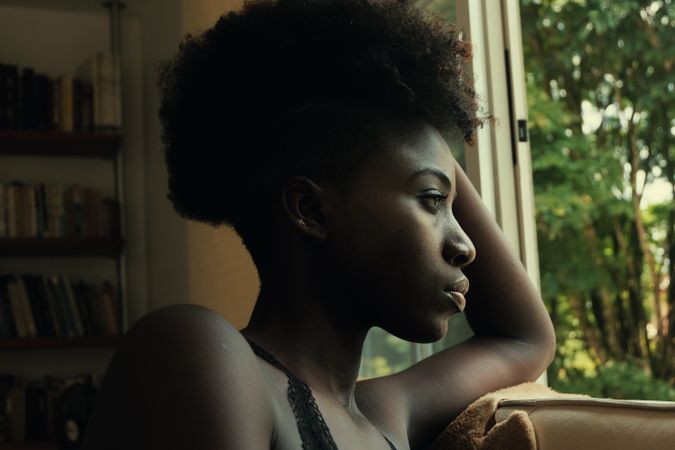 Black female leaning on a window