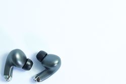 Top view of wireless earbuds on plain table with copy space