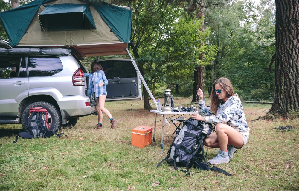 Woman packing backpack for a hiking trip