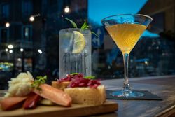 Elegant cocktail and appetizer platter in a stylish bar at night