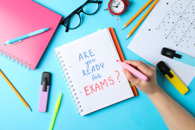 Hand writing “Are you ready for exams” written in notebook on blue background