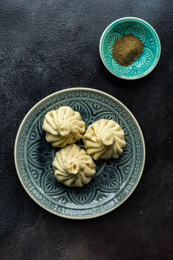 Top view of patterned plate with three Georgian khinkali dumplings