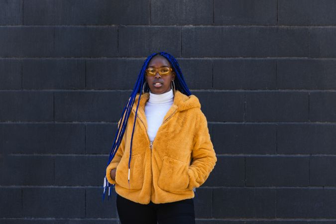 Stylish Black woman in yellow coat in city