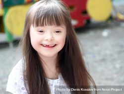 Portrait of a young girl with Down syndrome with long straight brown hair 0WV1Pb