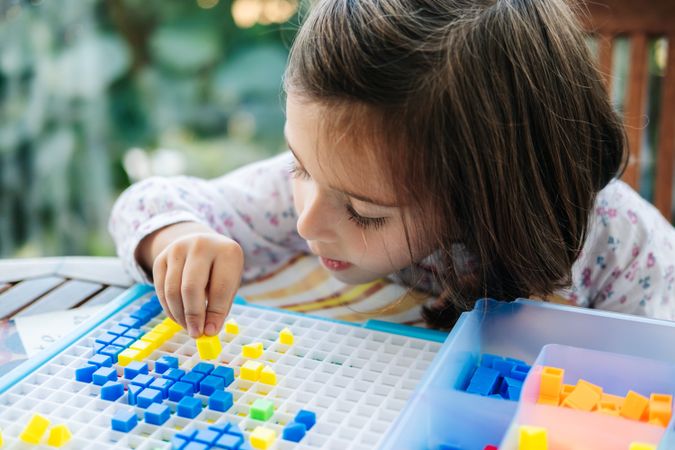 Girl playing with mosaic board game
