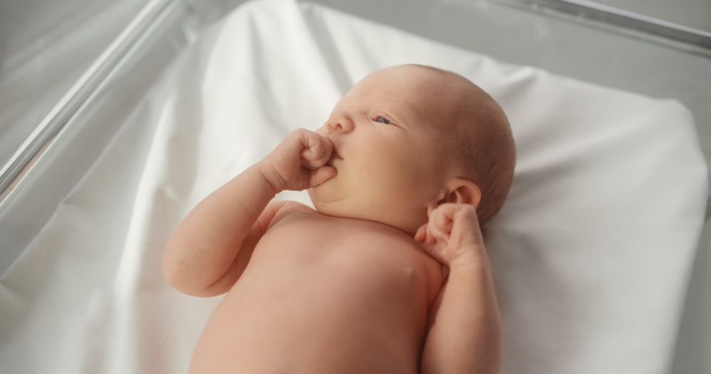 Adorable Small Newborn Child Lying in Hospital Bed in a Nursery Clinic.
