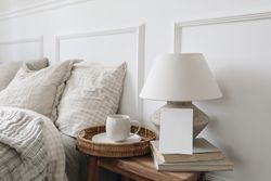 Bedside table with tray of coffee, lamp and mockup card