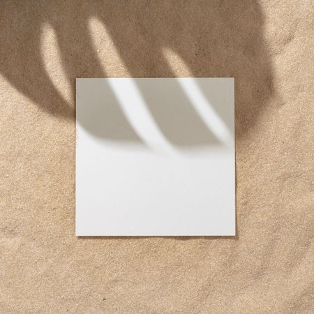 Sand with palm leaf shadows and central square