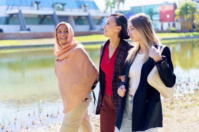 Three women having a conversation while strolling along river bank