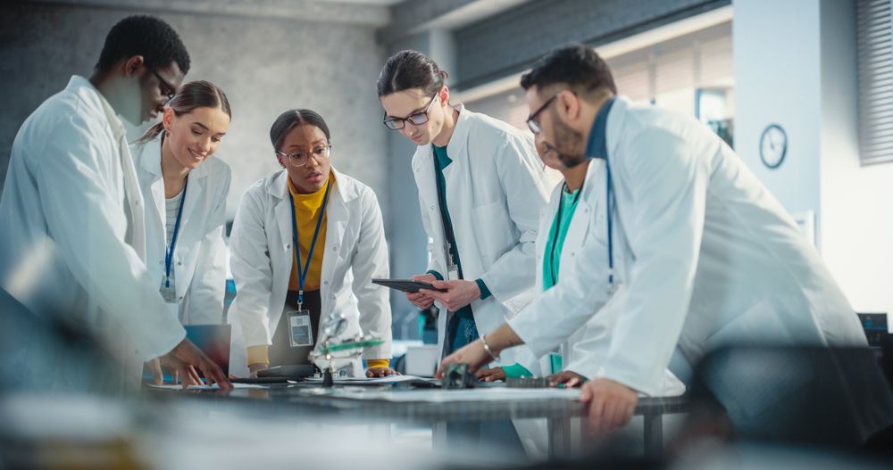 International Manufacturing Project Managers Discussing Data Gathered in Product Analysis Using Laptop and Tablet Computers.