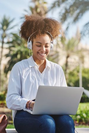 Black woman working on netbook in park