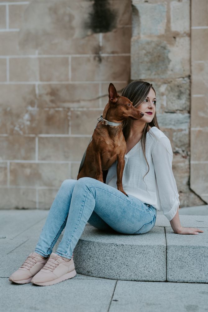 Woman with purebred dog on stone porch