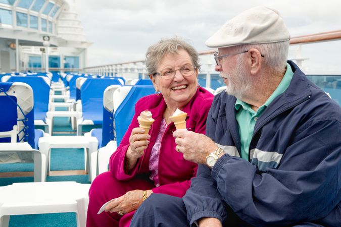 Happy Mature Adult Couple Enjoying Ice Cream On The Deck of a Luxury Passenger Cruise Ship.