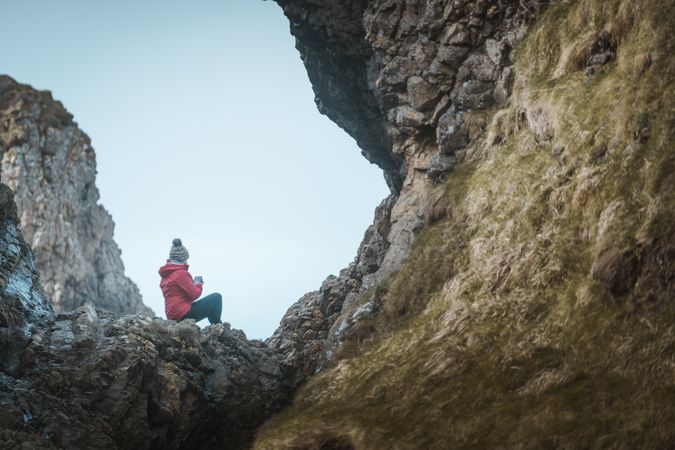 Woman sitting inside rocky cave