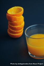 Stack of squeezed tangerines and a glass of juice 5zlemb
