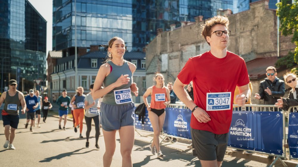 Group of Diverse People Running in a Marathon with the Cheers of their Loved Ones and Supporters in the Audience.