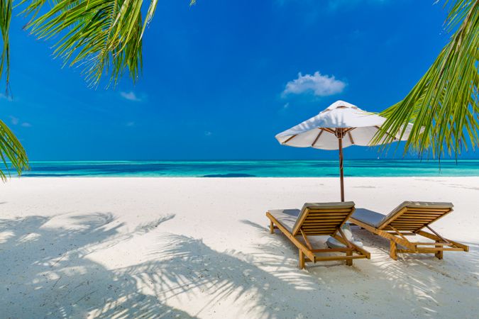 Two reclining lounge chairs on an idyllic beach, landscape