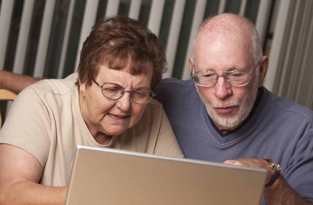 Smiling Mature Adult Couple Having Fun on the Computer