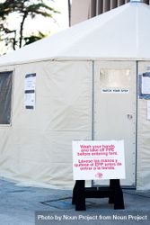 Sign in front of safety tent at public coronavirus test site requiring hand washing 5kR930