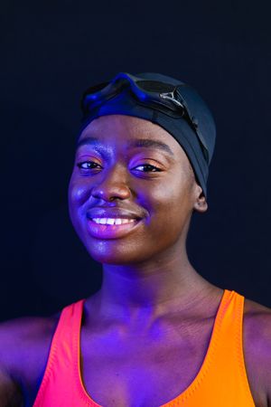 Portrait of female Black swimming with colorful lighting and dark background