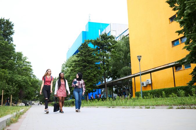 Multi-ethnic female friends walking through campus on an overcast day