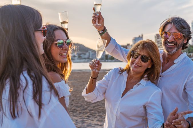 Happy family drinking wine on beach