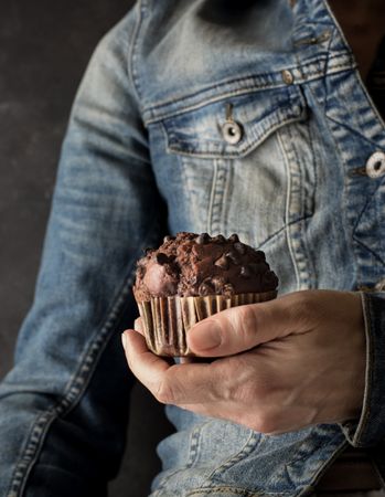 Crop woman with chocolate banana muffin