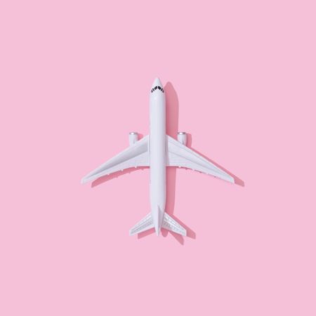 Passenger plane on pastel pink background