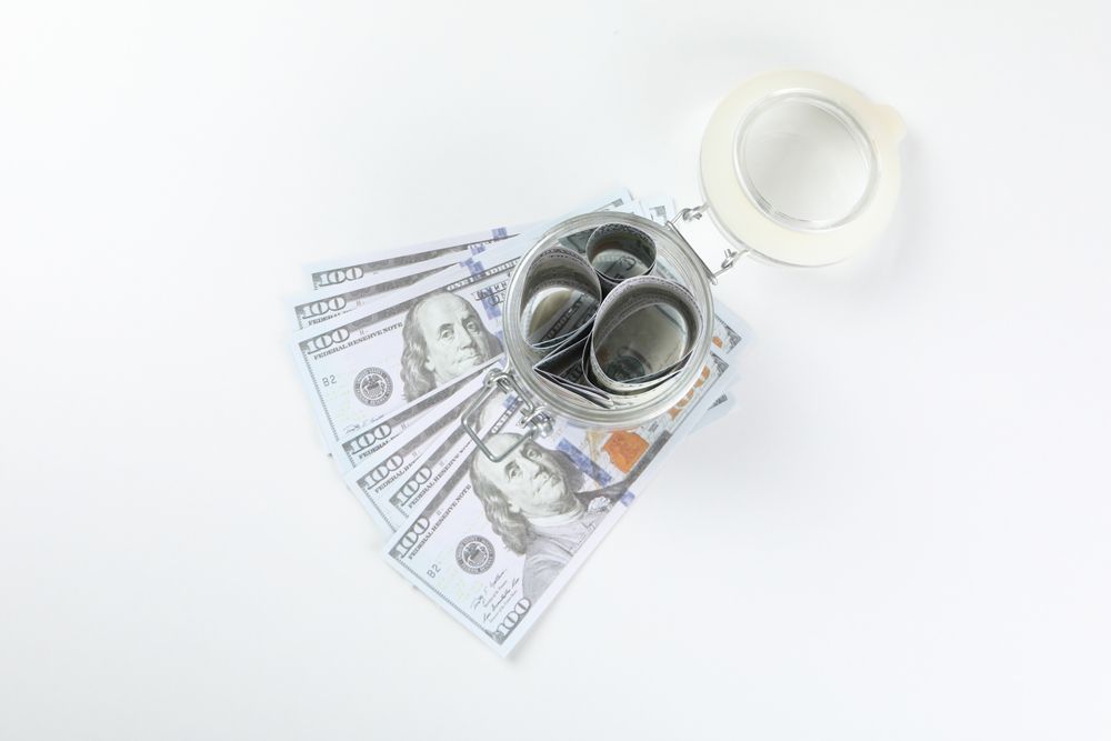Jar with Dollar bills on light background