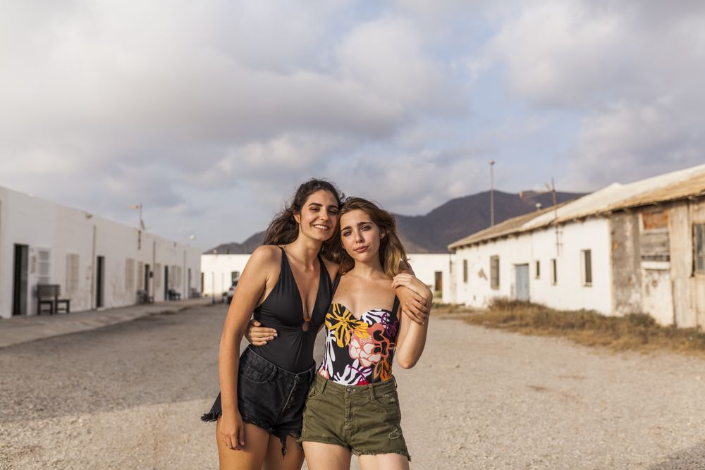 Women hugging on old town street