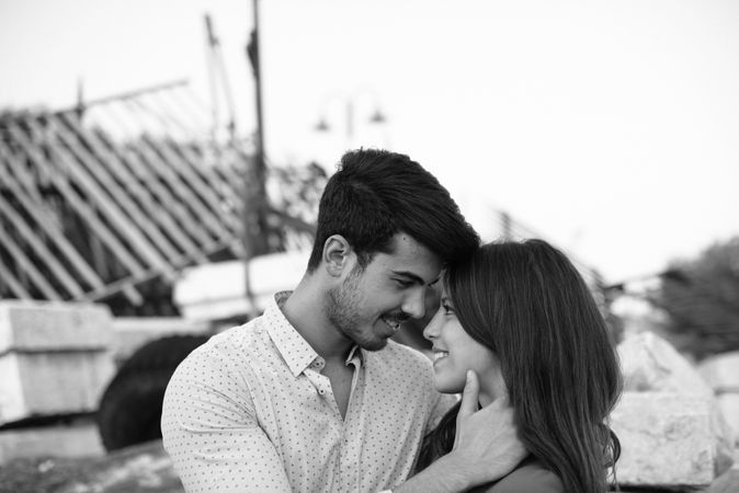 Loving couple hugging in abandoned building with metal fence