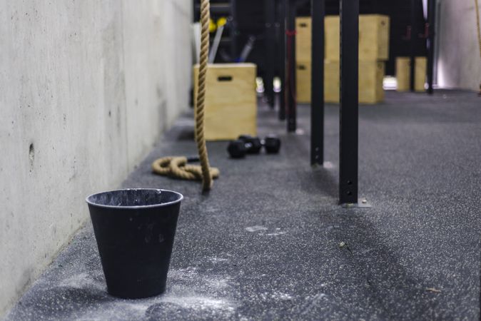 Rope near bucket of chalk in gym