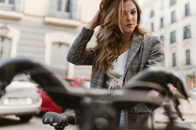 Woman choosing rental bicycle on parking lot
