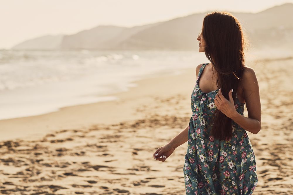 Young woman in the beach at sunset