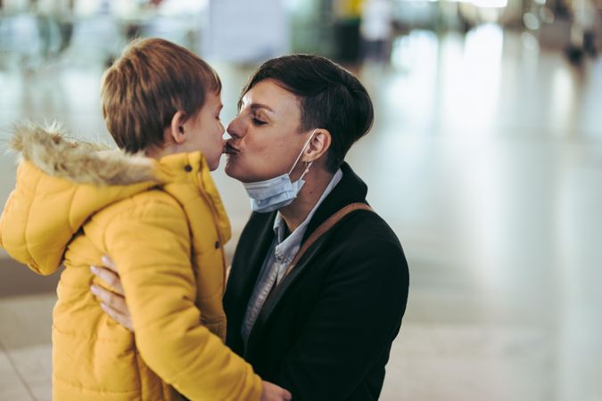 Woman kissing her son at airport